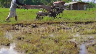 东南亚的农<strong>民用</strong>手拖拉机犁稻田。 旅游亚洲概念。 慢动作视频
